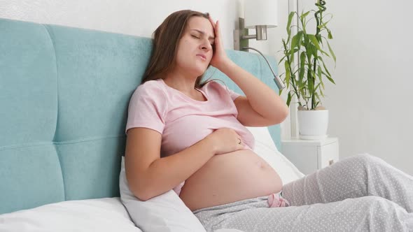 Young Pregnant Woman Feeling Unweel Suffering From Headache and Lying in Bed
