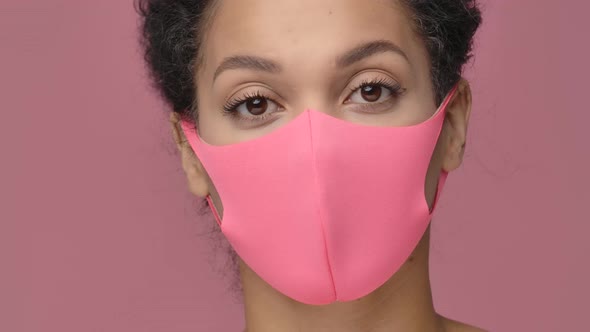 Beauty Portrait of Young African American Woman in Pink Protective Pitta Mask Looking at Camera