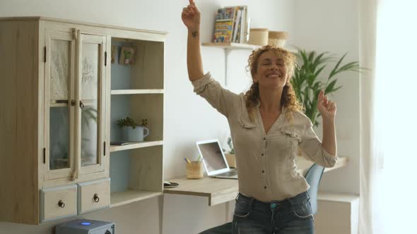 Overjoyed excited woman caucasian at home dancing with joyful and happiness alone in living room