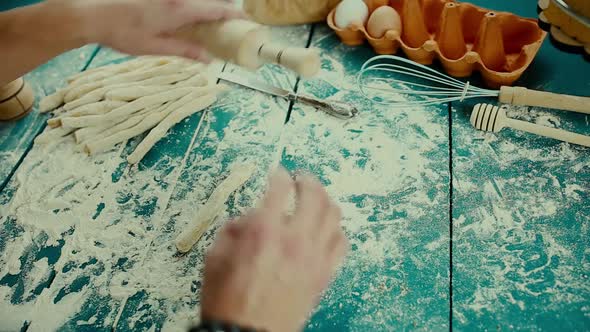 Baker Hands Preparing Fresh Dough with Rolling Pin on Kitchen Table. Man Forming the Dough on a