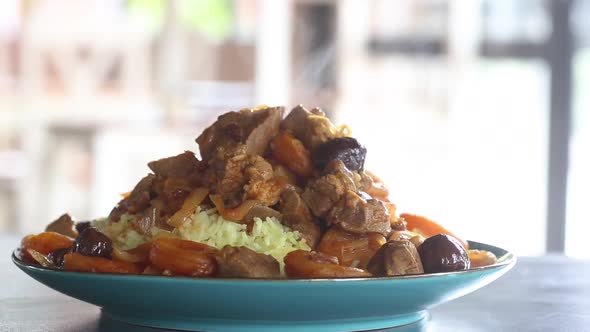 Hot cooked pilaf is on the table, steam emanates from it