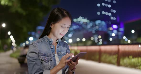 Woman use of mobile phone in city at night