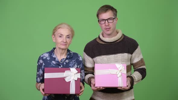 Happy Grandmother and Grandson Holding Gift Box Together