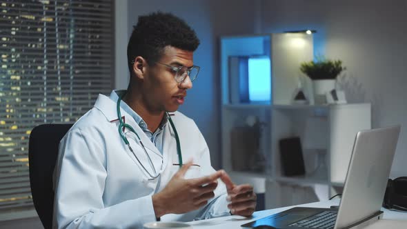 Young African Doctor Showing How To Wear Medical Mask By Video Call on Computer