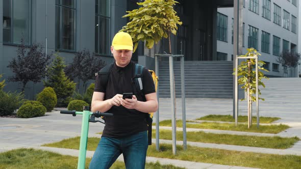 A Courier Takes an Order on a Smartphone Showing a Thumbs Up Into the Camera