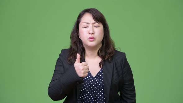 Mature Tired Asian Businesswoman Giving Thumbs Up