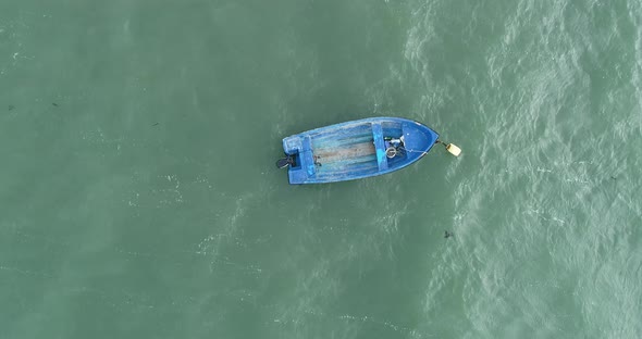 Top down view of lonely fishing boat in ocean, sea.