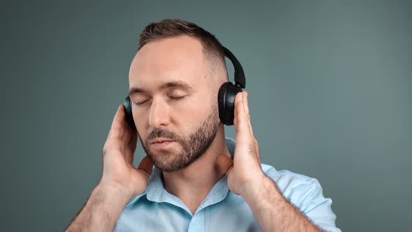 Closeup Face of Bearded Young Male Listening Music Wearing Headphones Isolated