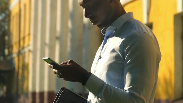 Close Up African American Young Attractive Man Using Phone on Street Sunlight Sunset Cellphone