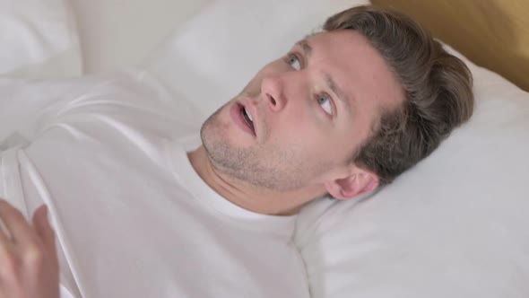 Shocked Portrait of Young Man Wake Up From Sleep