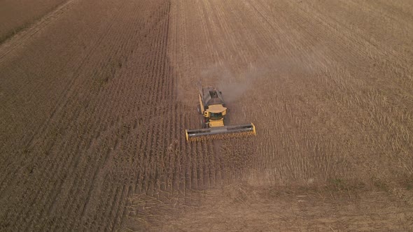 Slow Motion Aerial View of Combine Harvester Working on a Field