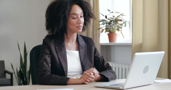 Joyful Young Mixed Race Businesswoman Freelancer in Black Jacket Holding Online Video Call 