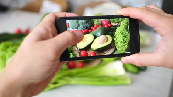 Woman Hands Takes Photo Of Healthy Organic Food On Table With Phone.