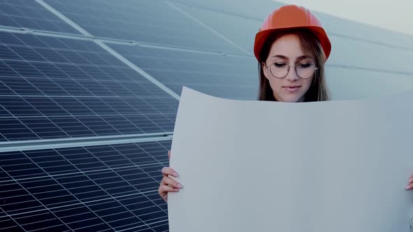 Handsome Architect Woman Examining a Draft Map or Blueprint Project Plan