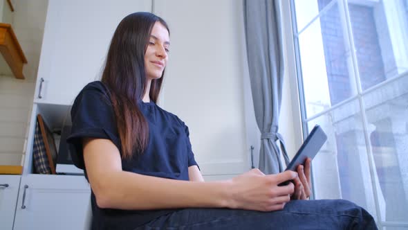 White girl browsing internet on modern tablet computer with cheerful smile in 4k video