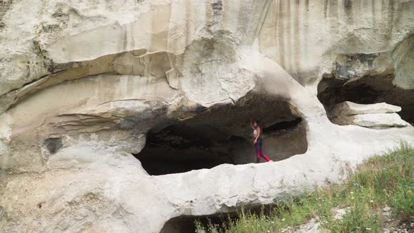 Girl Traveler Walks Through Cavern. Cave City in Vicinity of Bakhchisarai - Tope Kermen in Crimea