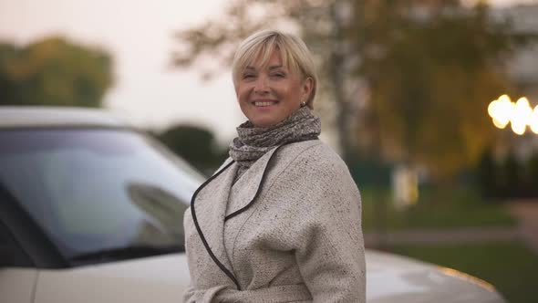 Mature Successful Woman Smiling and Holding Keys of New Luxury Car, Present