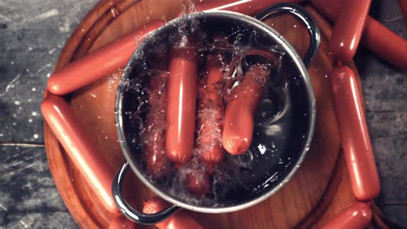 Super Slow Motion a Bunch of Sausages with Spray Falls Into a Pot of Water