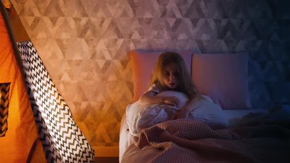 Frustrated Girl Stares Into Vacancy Sitting on Bed By Tent