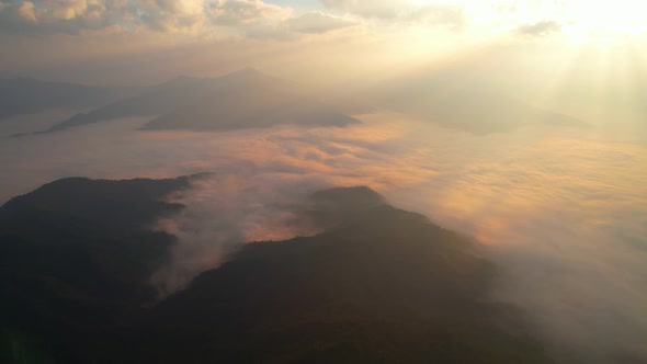 Aerial view from drone, Epic sunbeam over sea of clouds mountains. 4K aerial shot on sunrise