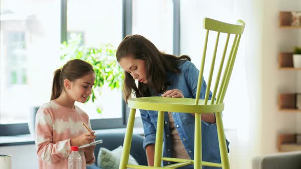 Mother and Daughter with Ruler Measuring Old Chair