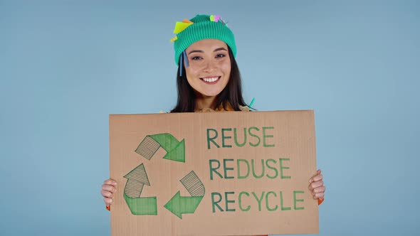 Woman holding cardboard with inscription reuse reduce recycle.