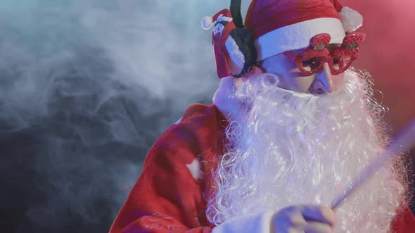 Drummer in a Carnival Costume of Santa Claus with a Beard Beats with Sticks on Drums and Percussion