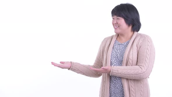 Happy Overweight Asian Woman Showing Something for Winter