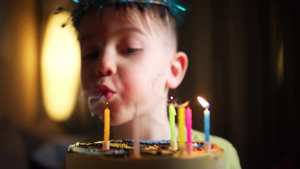 Closeup of Charming Caucasian Little Boy Making Wish and Blowing Candles on Birthday Cake