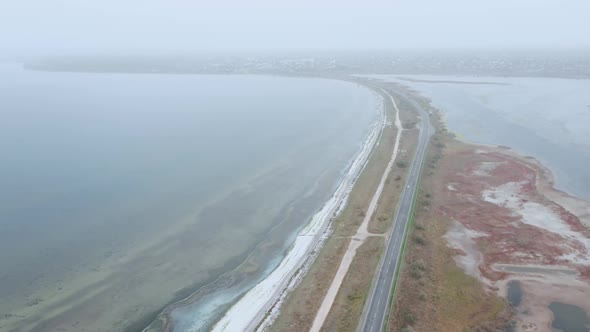 An Aerial View of a Car Rushing Along the Highway in the Fog