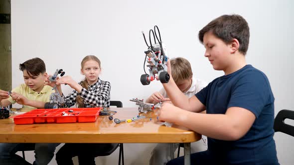 Boy Playing with Robot in Classroom