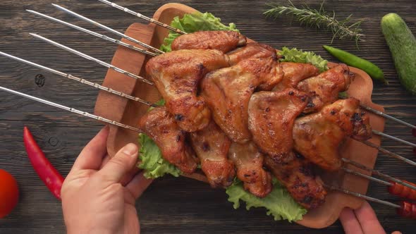 Top View of a Wooden Plate Full of Delicious Fried Chicken Wings on the Skewers