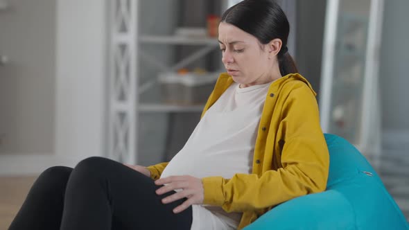 Side View Pregnant Woman Having Contractions Calling Hospital Talking on Phone