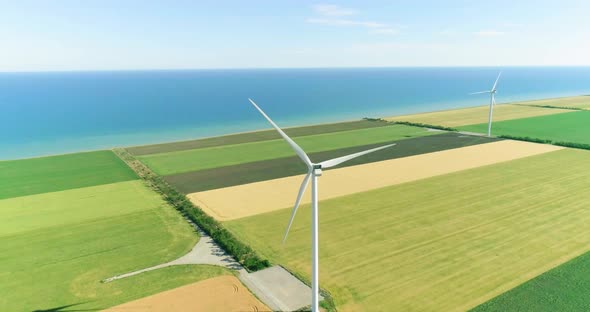 Group of windmills for electric power production in the agricultural fields. Aerial view.