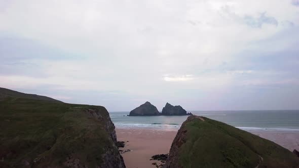 Revealing shot of the distant rocky island. Carters rocks, Holywell Bay, Cornwall.