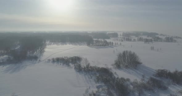 Aerial View of Cold Winter Landscape Arctic Field Trees Covered with Frost Snow Ice River and Sun