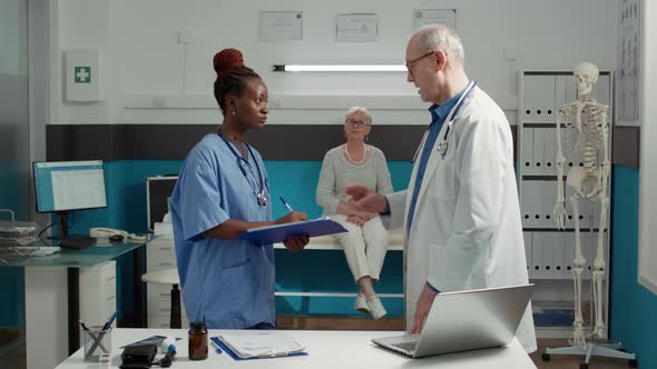 Doctor and African American Nurse Talking About Patient Diagnosis