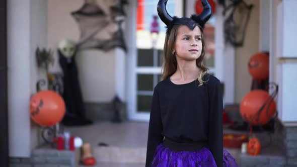 Portrait of Pretty Girl in Halloween Costume Standing Outdoors Waiting As Boy Walking Out Decorated