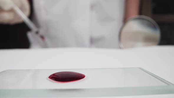 Slide with Blood Drop and Woman with Pipette and Loupe