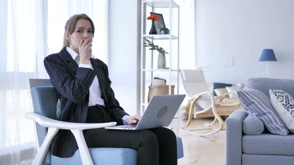 Woman in Shock Looking at Camera while Working on Laptop