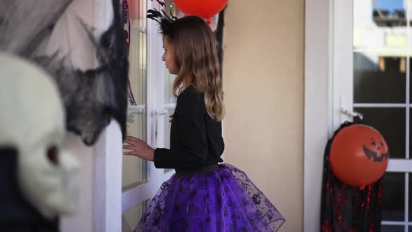 Side View Portrait of Pretty Caucasian Girl in Costume Standing at House Decorated for Halloween