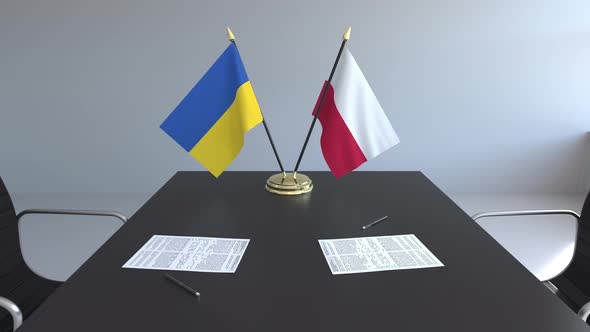 Flags of Ukraine and Poland and Papers on the Table