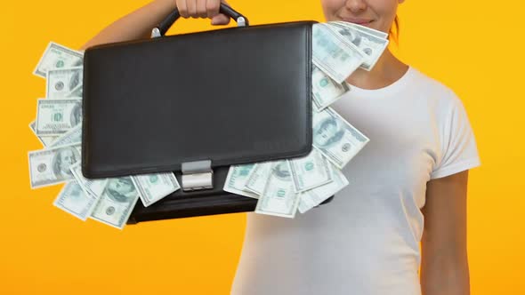 Woman Pointing Finger Into Brief Case Full of Money, Banking Credit Service