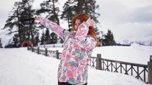 Happy Girl in Skiing Equipment Whirls and Smiles of Snowy Mountains and Forest