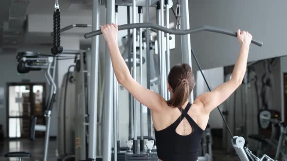 Fitness Woman Working Out in the Gym Doing Exercise for Back