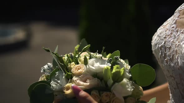 The Bride Holds a Beautiful Bouquet in Her Hands
