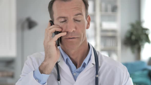 Senior Doctor Talking with Patient on Phone