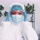 Young Multiethnic Female Doctor Wears Disposable Medical Suit and Mask Adjusting Eyeglasses During - VideoHive Item for Sale