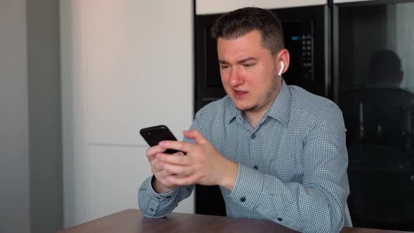 Caucasian business man developer receiving bad news on smartphone indoors