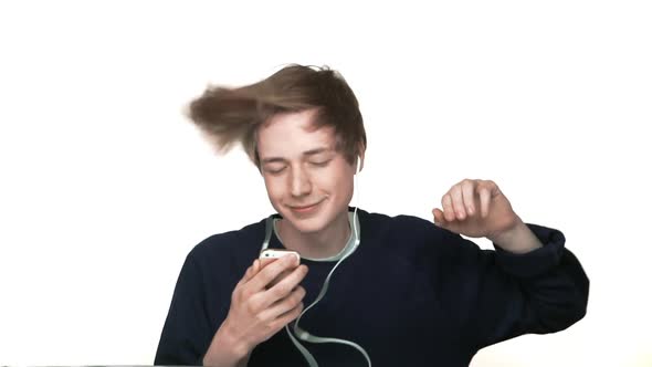 Portrait of Hipster Boy in Braces Listening His Favourire Music on Smartphone with Headphones